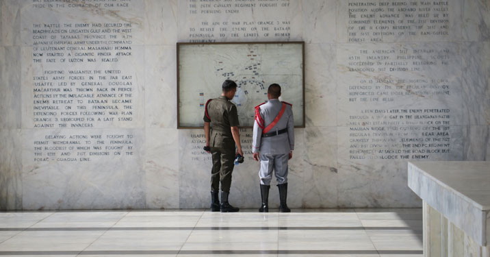 Filipino Soldiers Reading a Bataan Memorial Wall in
